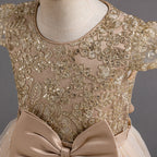 Gros plan sur les broderies dorées et les paillettes scintillantes du bustier