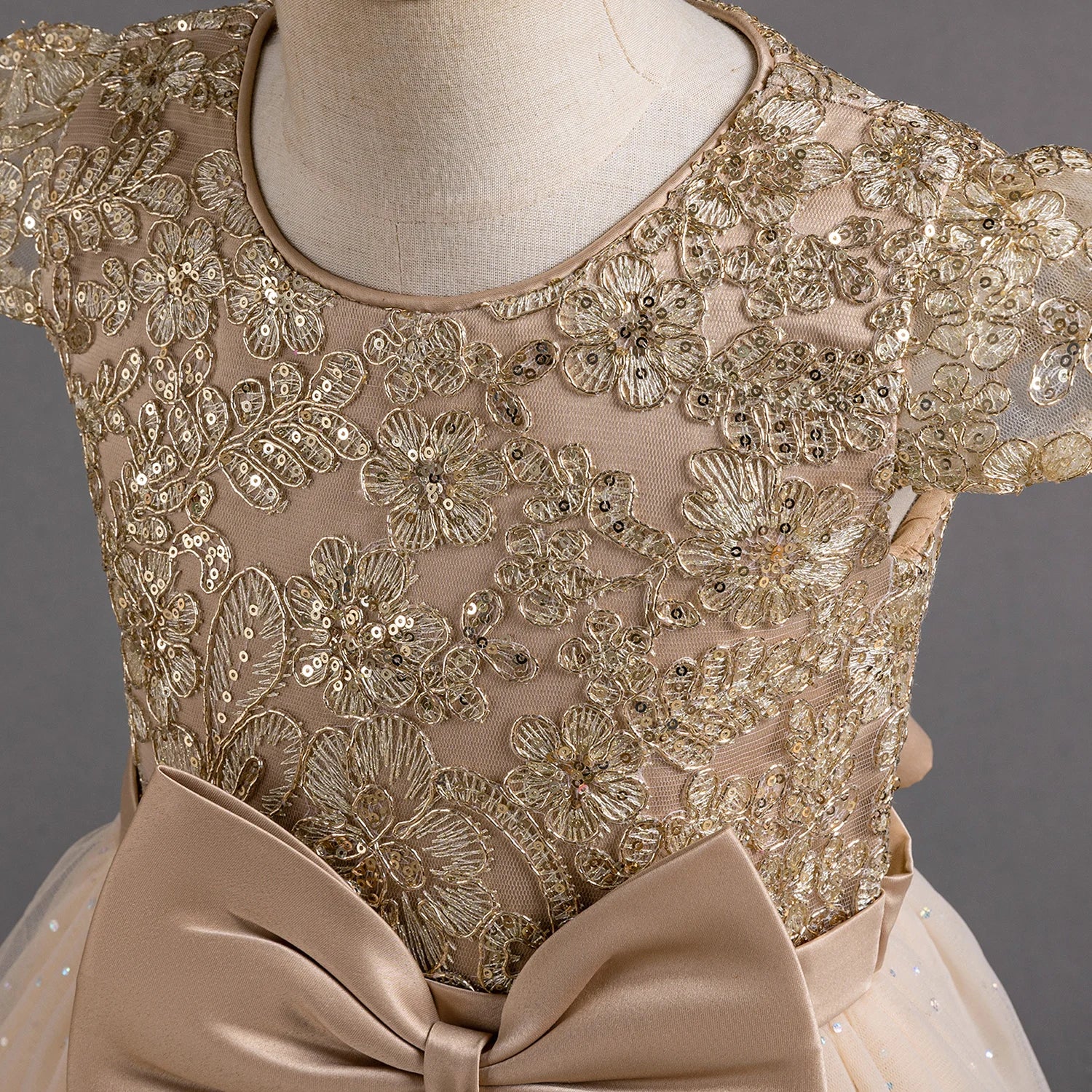 Gros plan sur les broderies dorées et les paillettes scintillantes du bustier