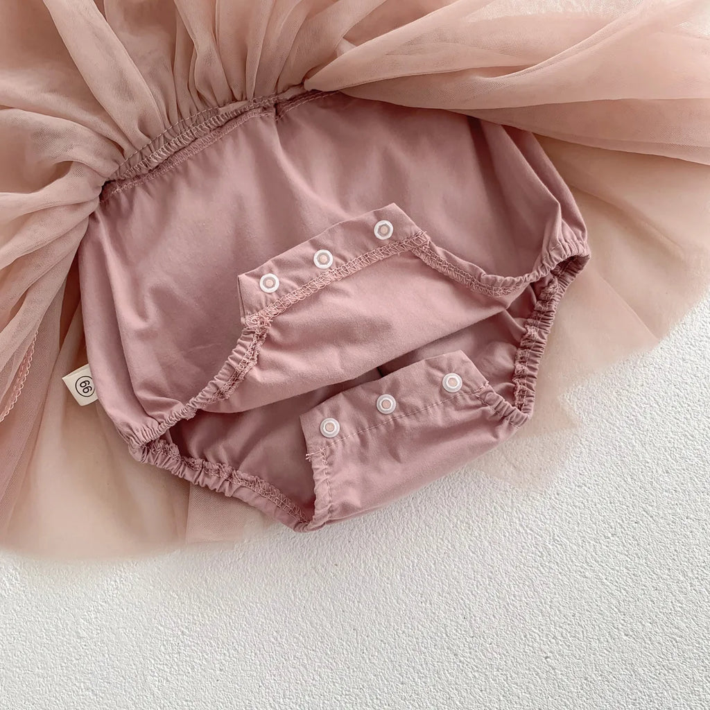 Gros plan sur la culotte bouffante intégrée sous le tutu de la barboteuse rose