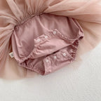 Gros plan sur la culotte bouffante intégrée sous le tutu de la barboteuse rose