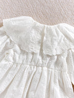 Détail du col Claudine en dentelle anglaise et broderies d'une barboteuse de baptême.