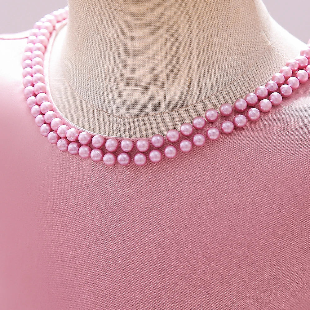 Zoom sur l'encolure avec perles brodées d'une robe de cérémonie rose