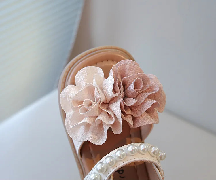 Gros plan sur les sandales Jade, soulignant le volume des fleurs en tissu et l'éclat des perles