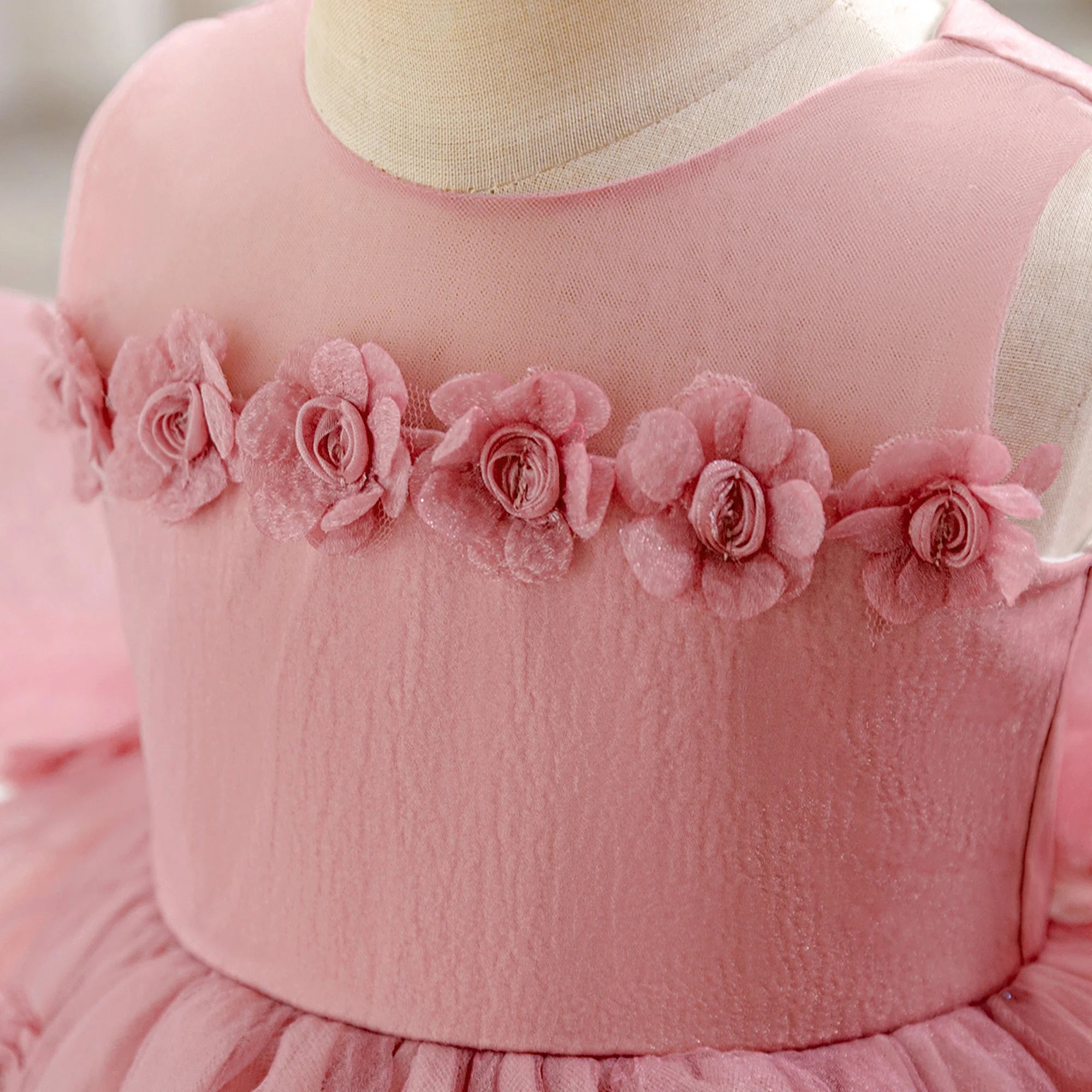 Zoom sur les fleurs en relief et les perles du bustier de la robe anniversaire.