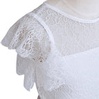 Détail des finitions en dentelle sur l'épaule d'une robe de fête pour enfant.
