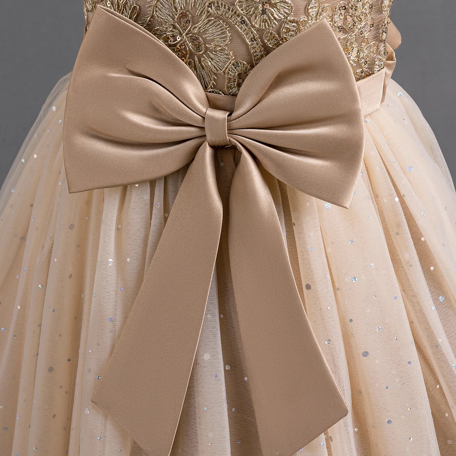 Détail du grand noeud en satin beige à la taille de la robe