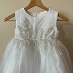 Détail des paillettes et motifs de sequins sur le bustier d'une robe de baptême