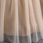 Gros plan sur le tissu en tulle pailleté de la jupe longue Lucia