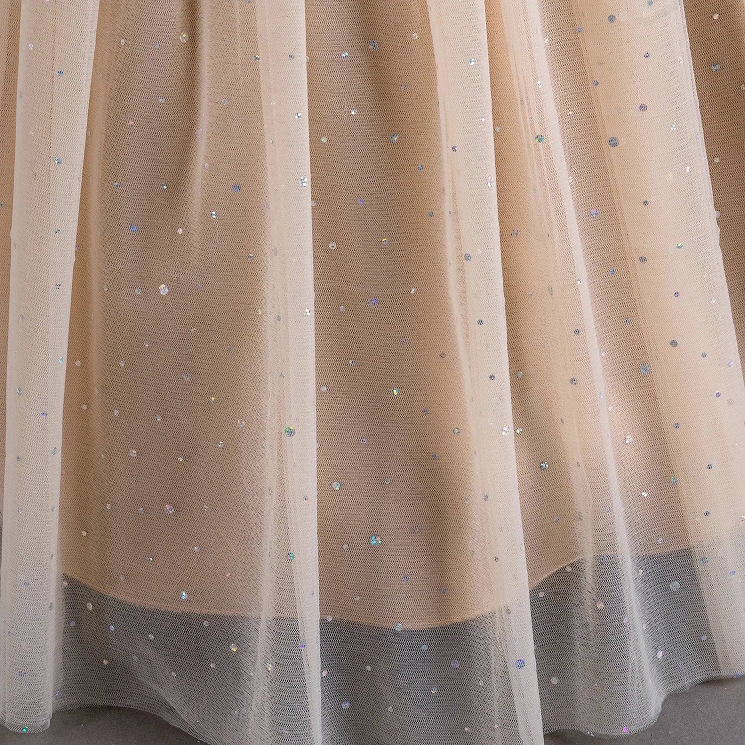 Gros plan sur le tissu en tulle pailleté de la jupe longue Lucia