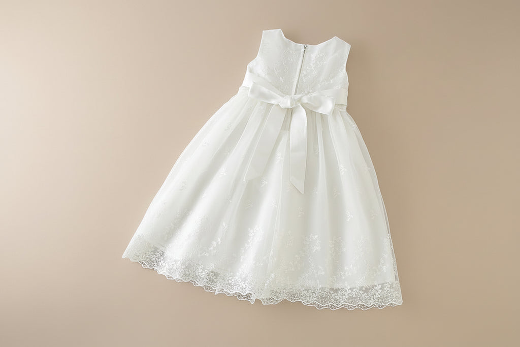 Détail du dos de la robe de baptême avec rangée de boutons perlés et finitions en dentelle