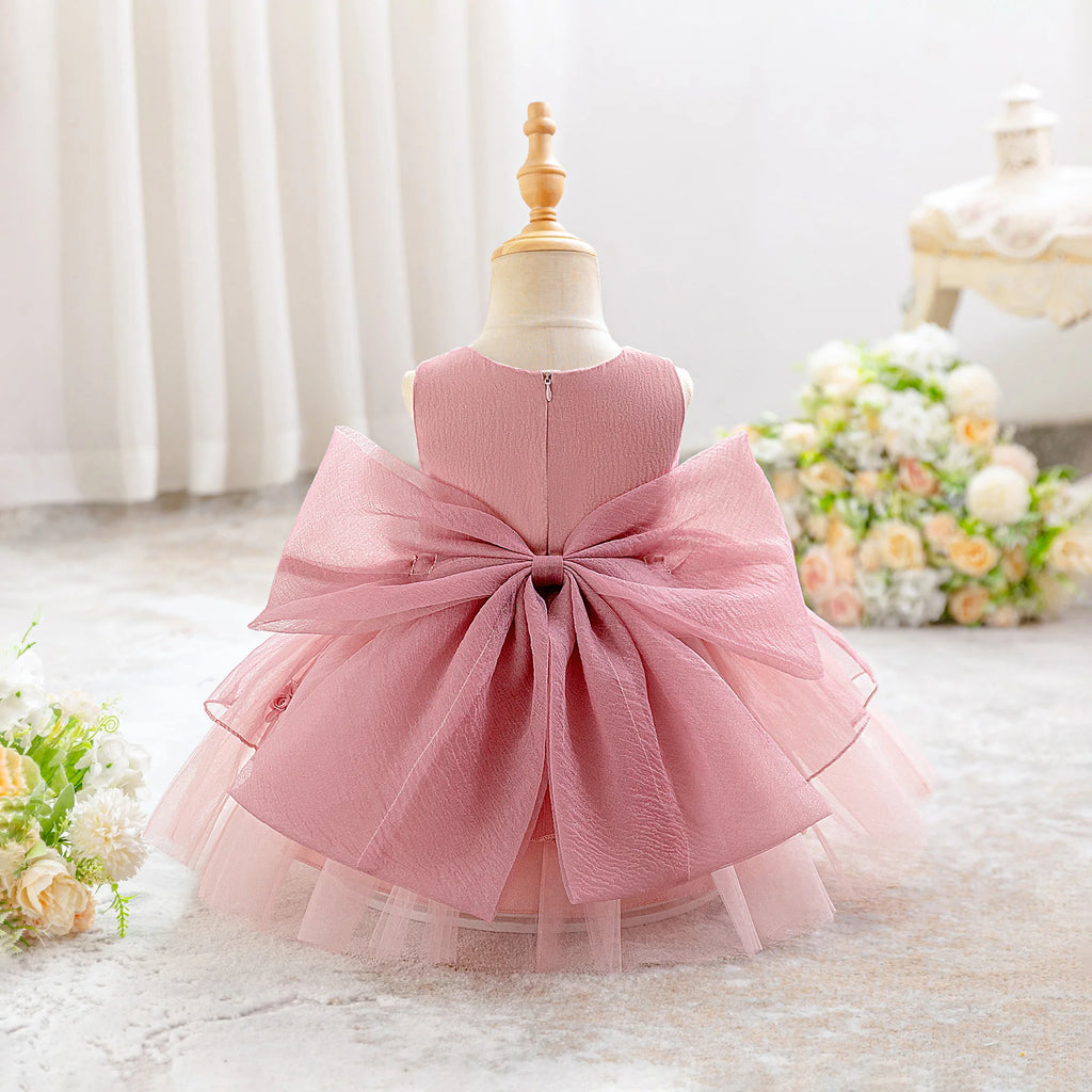 Dos de la robe de fête bébé avec grand nœud satiné et fermeture éclair.