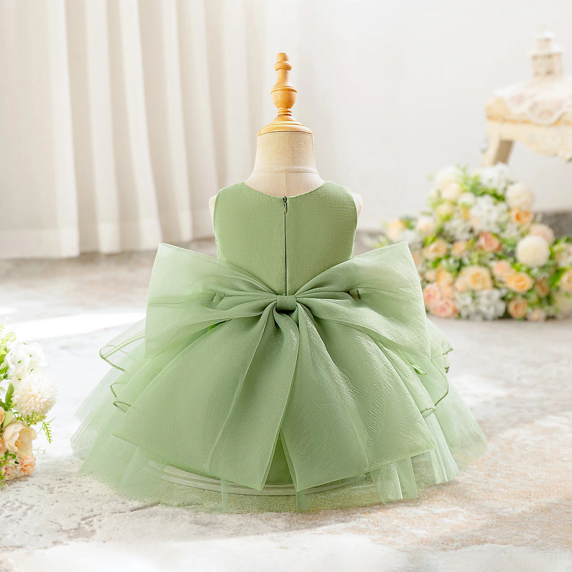 Dos de la robe de fête bébé couleur vert menthe avec nœud bouffant.