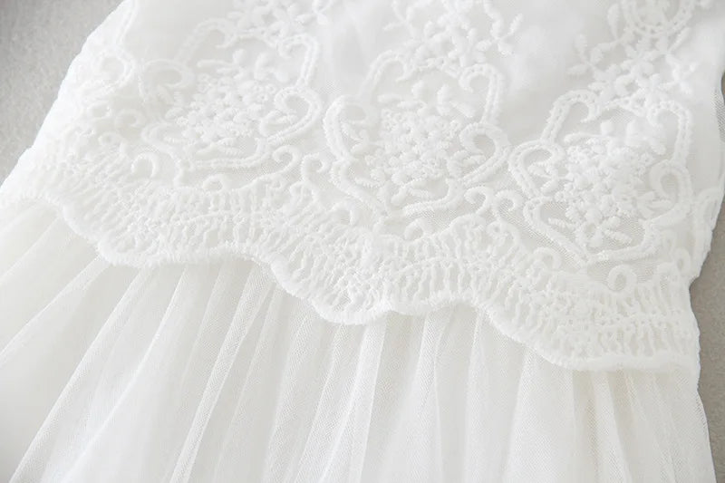 Détail de la jonction entre le bustier en dentelle et la jupe en tulle de la robe de baptême