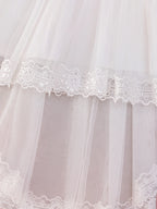 Détail des épaisseurs de tulle vaporeux et de la finition bordée de dentelle fine sur le bas de la robe