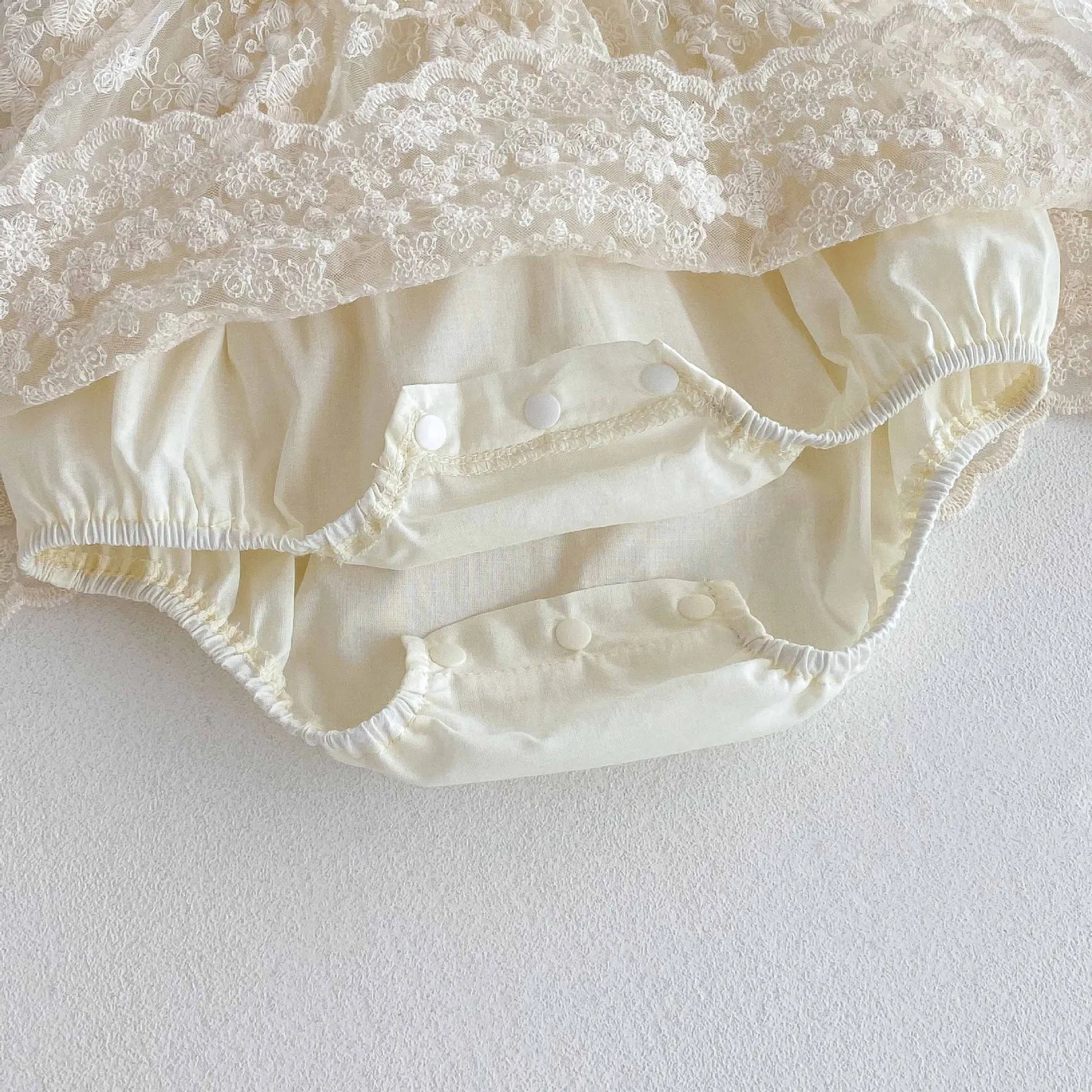 Vue du bas de la barboteuse Juliette montrant les boutons pressions à l'entrejambe pour un change facile