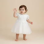 Bébé fille portant une robe de baptême blanche style old school avec bustier en dentelle