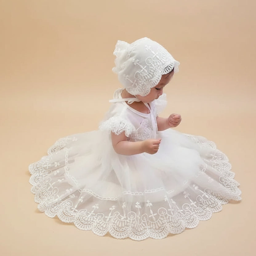 Bébé portant une robe de baptême traditionnelle blanche avec son bonnet en dentelle assorti