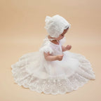 Bébé portant une robe de baptême traditionnelle blanche avec son bonnet en dentelle assorti