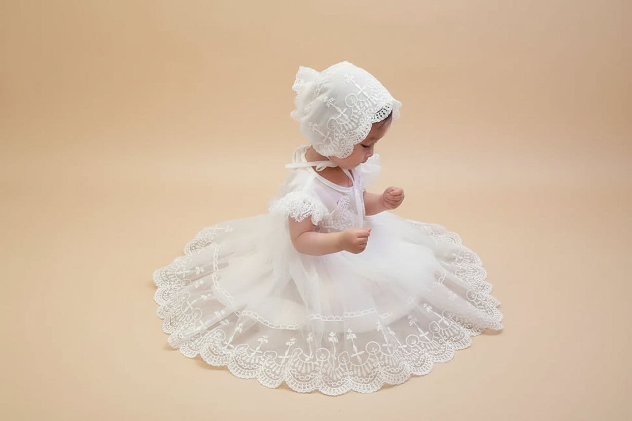 Bébé portant une robe de baptême traditionnelle blanche avec son bonnet en dentelle assorti