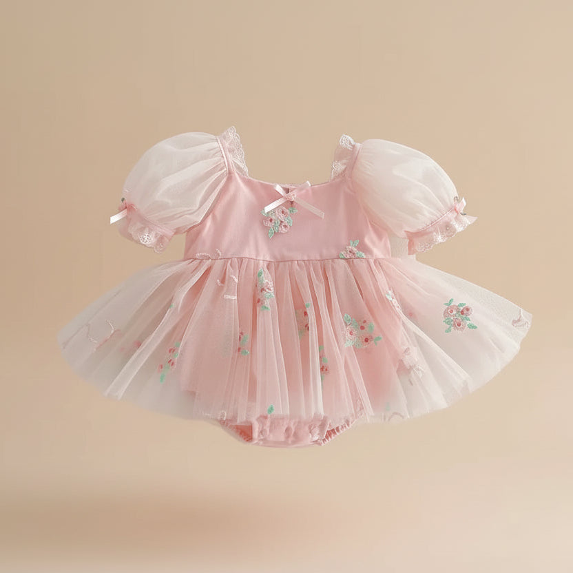 Robe barboteuse style princesse rose avec manches bouffantes pour fête de bébé.