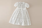 Vue de face de la robe de cérémonie blanche sans manches avec petit nœud discret à la taille