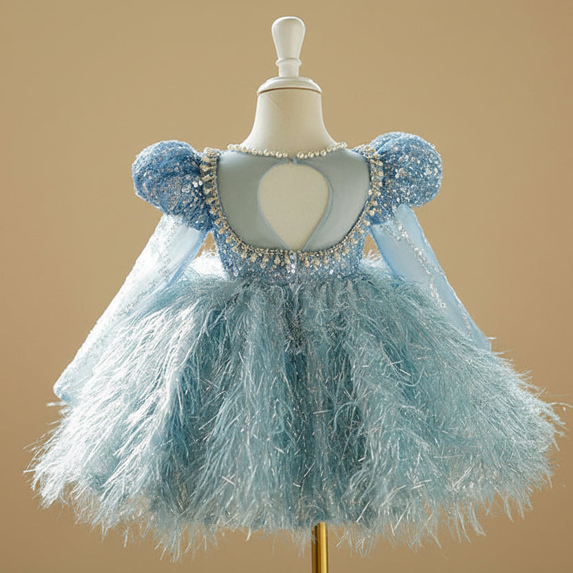 Vue arrière de la robe de cérémonie bleue montrant le volume de la jupe à plumes.