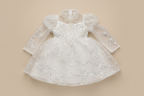 Vue de face de la robe de cérémonie Juliana blanche montrant les broderies et le tulle volumineux