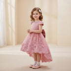 Petite fille portant une robe de cérémonie rose avec traîne et détails en dentelle