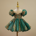 Vue sur mannequin de la robe de cérémonie vert et or avec épaulettes bouffantes structurées