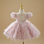 Vue arrière de la robe de cérémonie rose montrant le volume de la jupe à plumes.