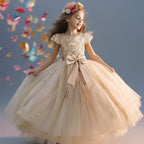 Petite fille portant la robe de gala longue Lucia couleur champagne avec bustier pailleté et jupe volumineuse