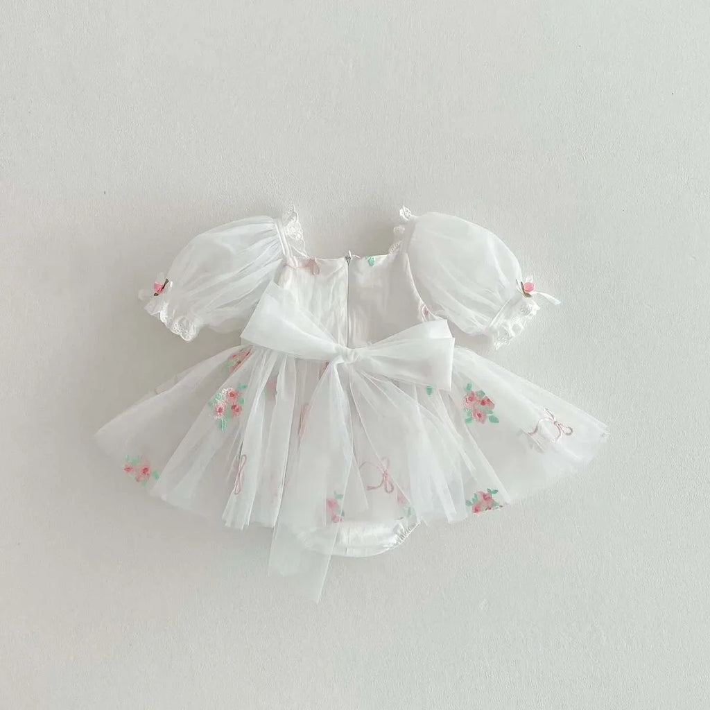 Tenue de cérémonie pour bébé fille en tulle blanc et finitions soignées.
