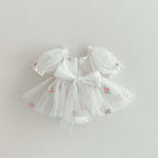 Tenue de cérémonie pour bébé fille en tulle blanc et finitions soignées.