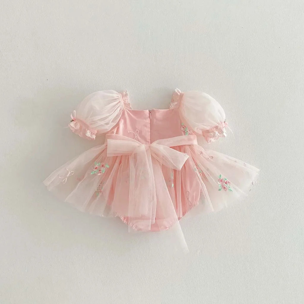 Vue de dos de la robe barboteuse en tulle rose montrant la coupe bouffante.