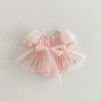 Vue de dos de la robe barboteuse en tulle rose montrant la coupe bouffante.