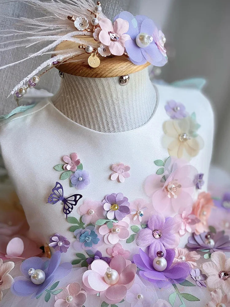 Détail du bustier avec une symphonie de fleurs en tissu, perles et papillons en relief