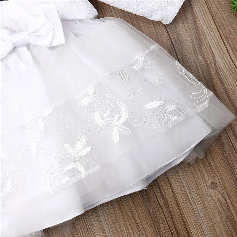 Détail des broderies et finitions de la dentelle sur le bas de la robe de baptême