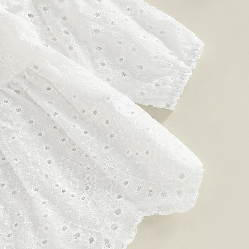 Détail de la manche longue volantée avec broderies d'une robe de cérémonie bébé