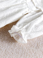 Zoom sur le tissu en coton et les finitions élastiquées de la barboteuse bébé.
