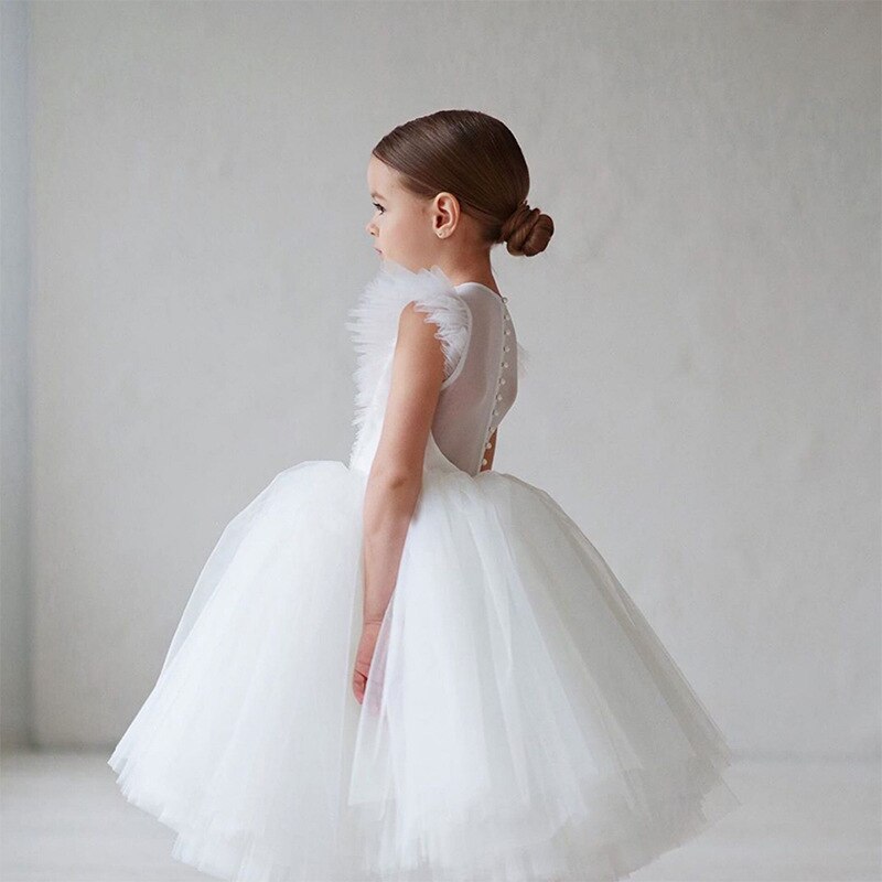 Vue de profil d'une enfant portant la robe de fête blanche mettant en avant le volume du jupon