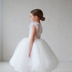 Vue de profil d'une enfant portant la robe de fête blanche mettant en avant le volume du jupon