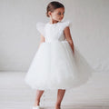 Petite fille portant une robe de princesse blanche avec épaulettes volantes structurées