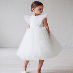 Petite fille portant une robe de princesse blanche avec épaulettes volantes structurées