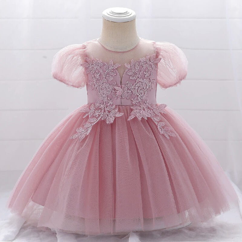 Gros plan sur les détails de la dentelle et des perles du bustier d'une robe rose foncé